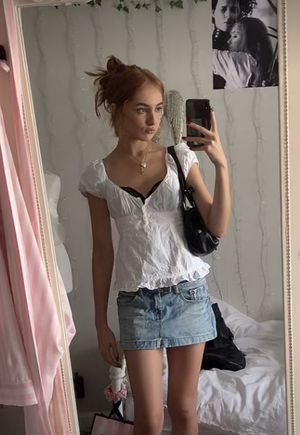 Selfie in white top and jean skirt in bedroom