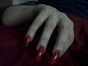 Dark red nails displayed.