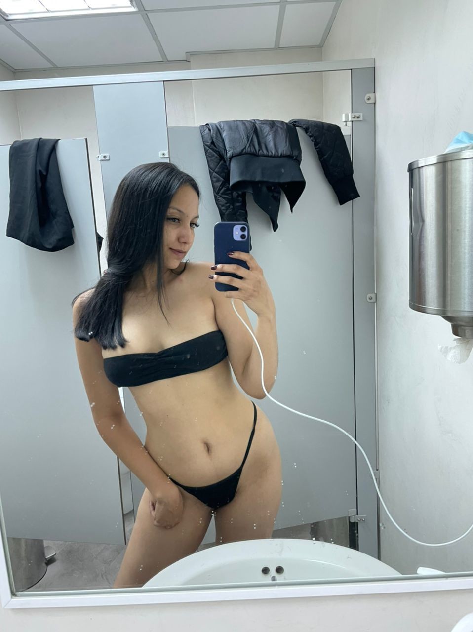 Carly strips for a selfie in the bathroom at work