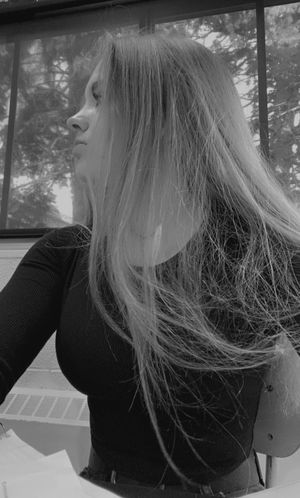 Blonde in black top with boob outline