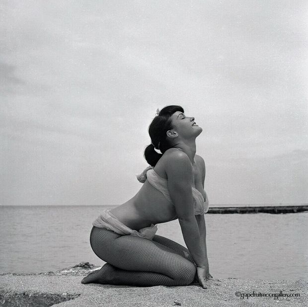 Bettie Page on the beach in fishnets