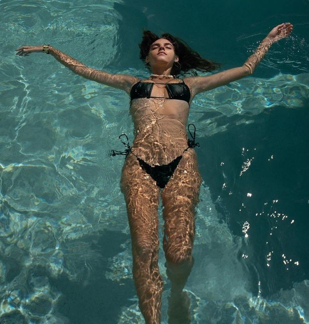 Emily spread out in a pool in bikini