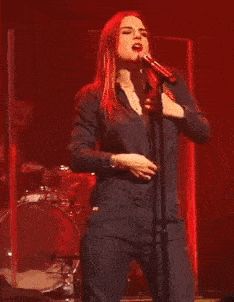 Joanna “JoJo” Levesque unzipping her suit and flashing her bra