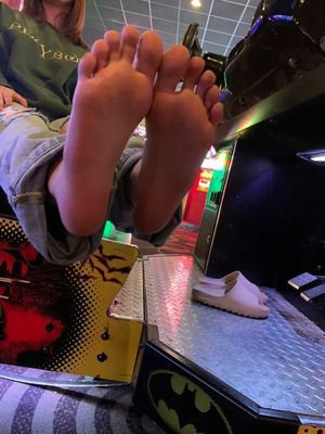 Friend shows off her feet at the arcade