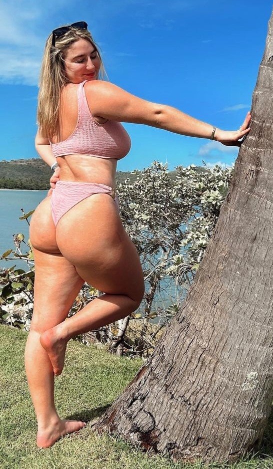 Jolie pink bikini showing ass beside tree