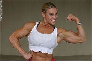 Collette Nelson flexing bicep and smiling