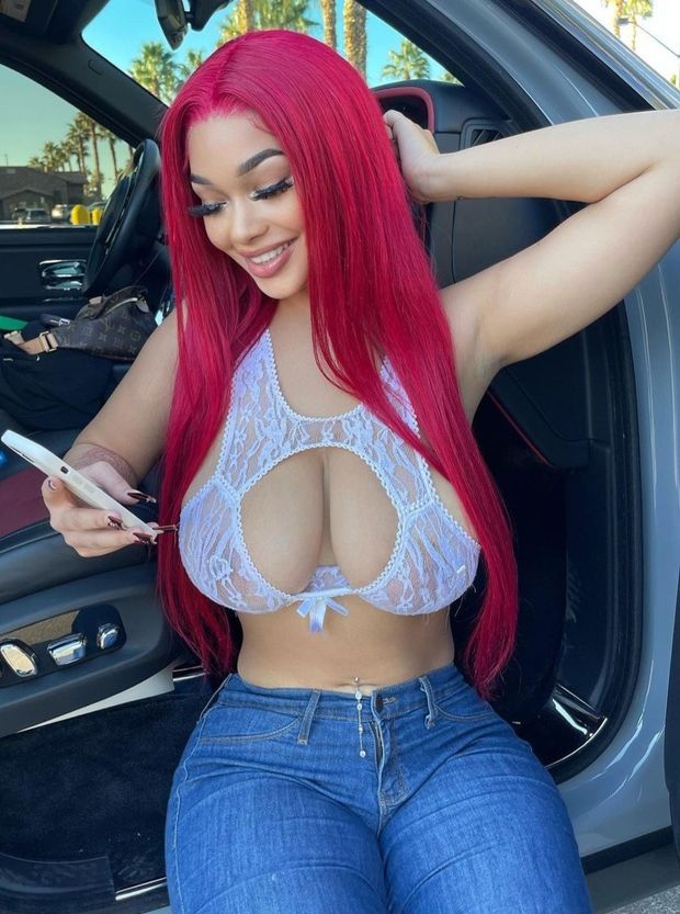 Lexie red head sitting in front of car