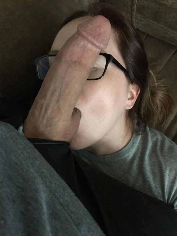 Amateur brunette with glasses has a huge cock placed on her face while sucking balls