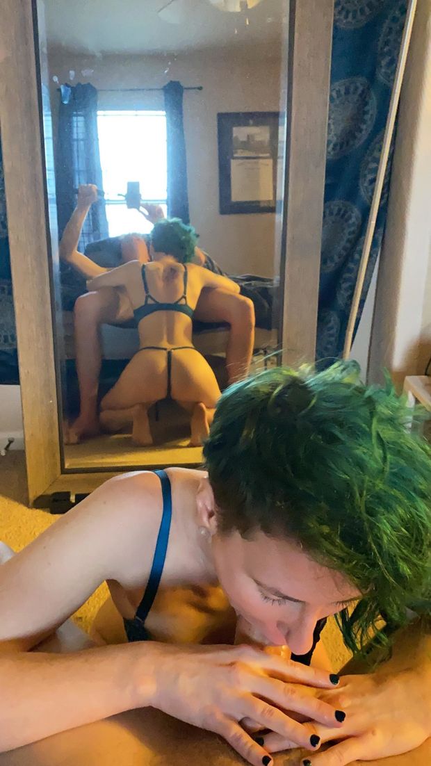 Hot amateur mirror-shot of a chick with green-hair, on her knees sucking a cock