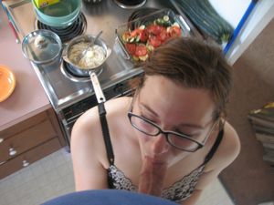 Brunette amateur with glasses in the kitchen sucking cock