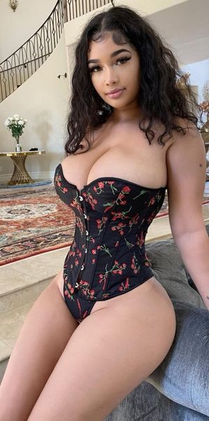 Lexie in bustier leaning on couch