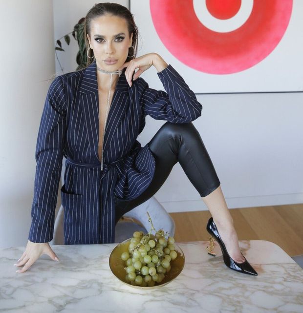 Charismatic brunette model wearing luxurious outfit and high heels