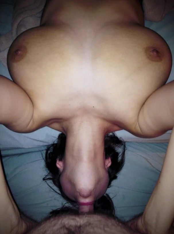 Brunette amateur with big tits giving a lie back blowjob
