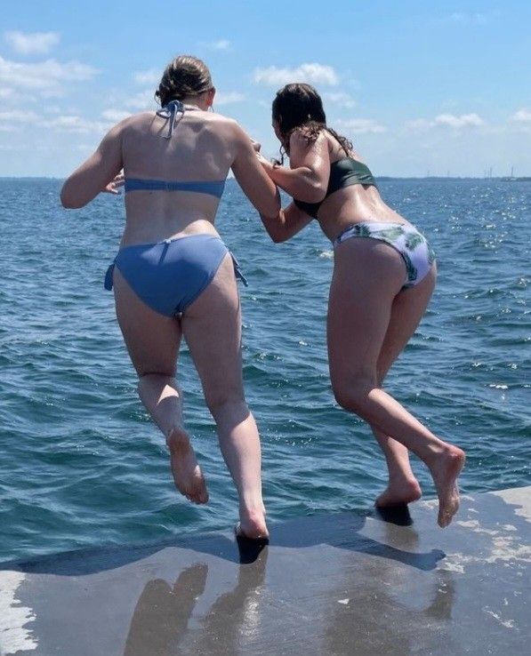 Teens jumping off concrete dock