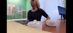 Chick lifting up her shirt as doctor prepares to place the stethoscope on her chest.