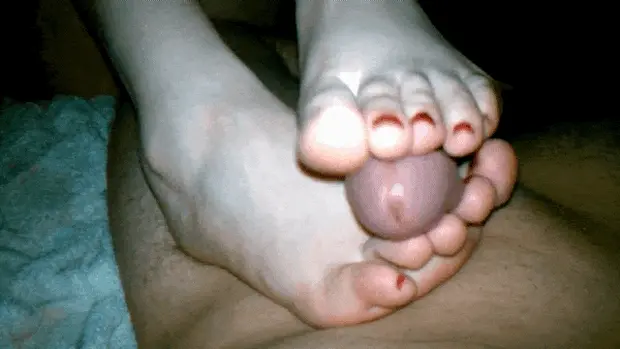 Amateur footjob with red toenails and precum