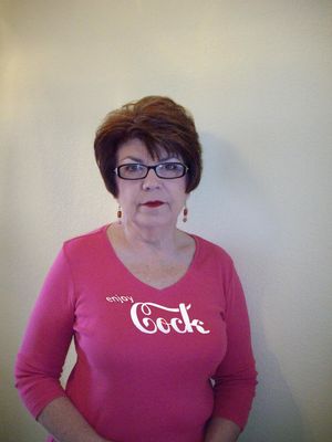 Sandy Ward's 36DD tits stretching her pink top that says she "enjoys cock."