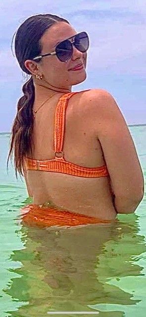 Sexy brunette in orange bikini showing ass