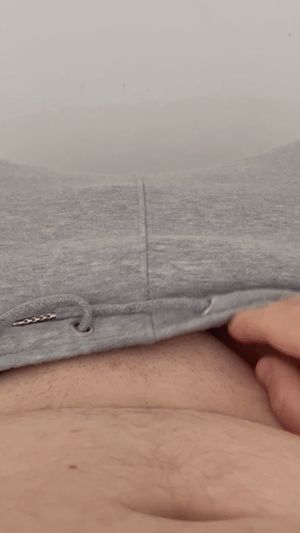 Pulling down sweatpants to reveal rock hard ringed cock