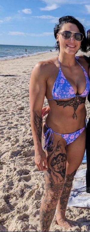 Rhea Ripley showing off her tattoos in a bikini