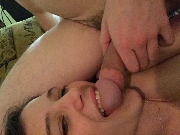 Brunette amateur smiling and taking a selfie with some cock in her mouth