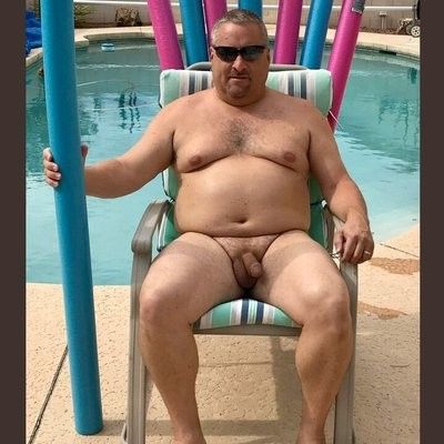 A naked mature man by a pool