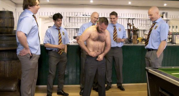 Man undressing in front of other men