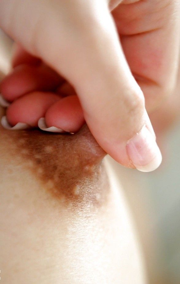 A close-up of a NUBILE NIPPLE, grasped between a THUMB & FOREFINGER, moments before it is PAINFULLY subjected to its first TITTIE TWISTER