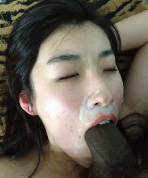 Asian amateur taking a load to her face from a black dick and still sucking after