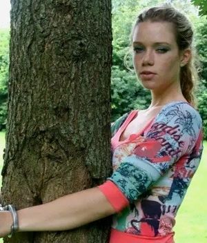 Woman handcuffed to a tree.