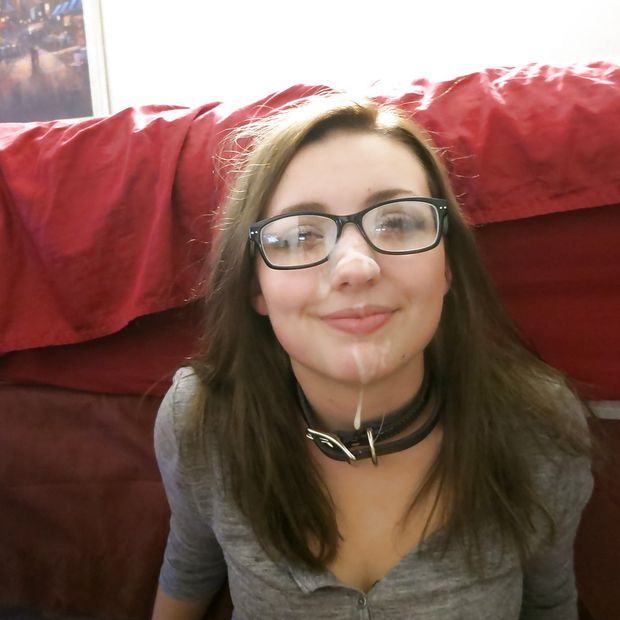 Cute amateur brunette in a collar with glasses and cum on her face